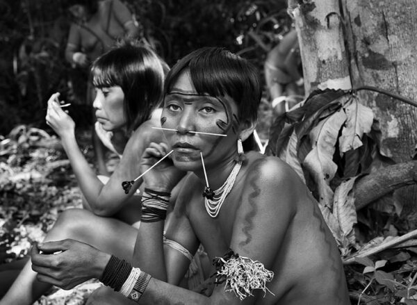 2 short haired Amazon Indian women sitting side by side.