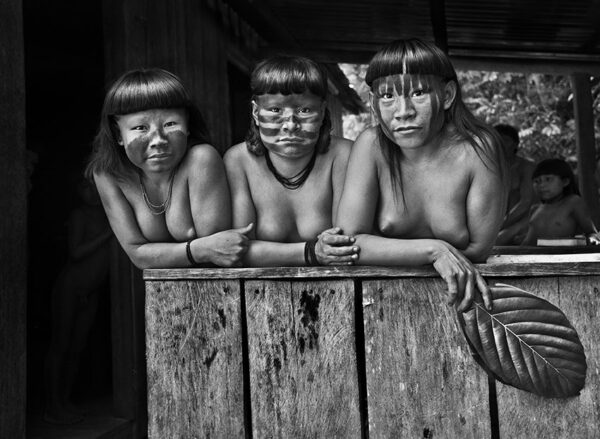 Trois jeunes filles nues, serrées côte à côte.