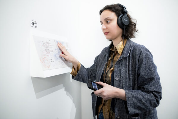 Femme avec des écouteurs touche une planche tactile avec la reproduction d'Eroica I et II